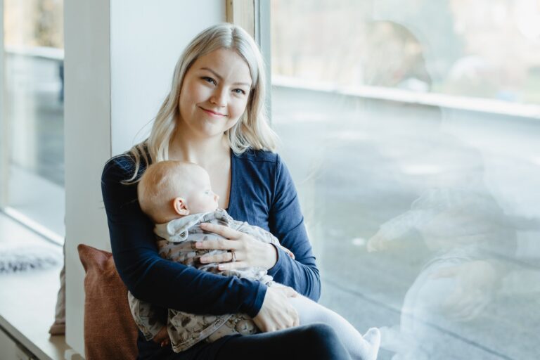 Janika pitää sylissä lastaan.